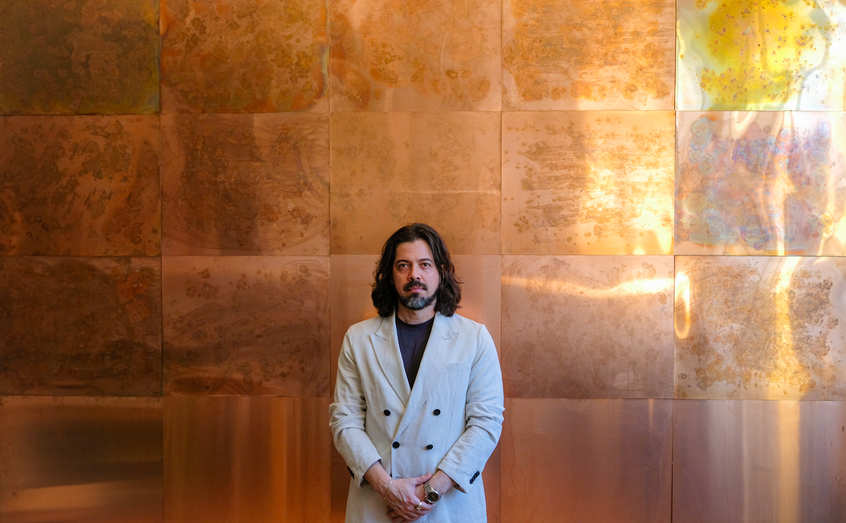 Jean Paul Winter standing in front of a copper painting
